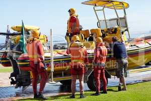 Getting ready to head out. Full length shot of a group of lifeguards preparing to go out to sea on a rescue mission.