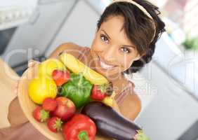 Ill cook you up something amazing. Portrait of a young woman holding a bowl full of fresh produce.