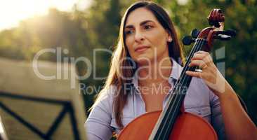 Music is the perfect way to calm the soul. Cropped shot of a beautiful woman playing a cello in the backyard.