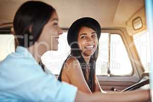 Road trips are always a good idea. Shot of two happy young friends going on a road trip.