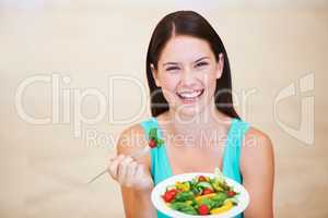 Enjoying a nutritional meal. Portrait of a happy young woman enjoying a salad.