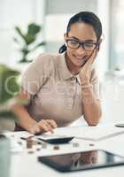 The key to successful economising is in setting goals. Shot of a young businesswoman calculating finances in an office.