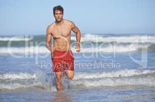 Rushing back to his post. A handsome young lifeguard running out from the sea.