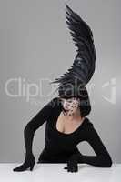 Let your imagination take wing. Shot of a young woman in a wing-shaped headpiece sitting in a studio.