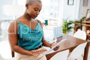 Whatever the task, technology will take care of it. Shot of a young businesswoman using a digital tablet in a modern office.