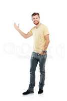 This is prime copyspace over here. Studio portrait of a young man pointing at blank copyspace while standing against a white background.