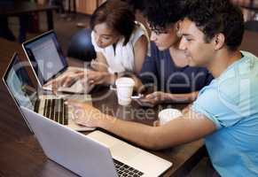Study group dynamics. A group of students using a laptop to complete a group assignment.