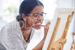 You dont have to be good to be considered an artist. Cropped shot of a beautiful young woman painting in a art studio.