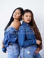 Looking funky and fresh. Studio shot of two beautiful young women posing against a grey background.
