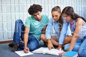 Going through the study material one more time.... Cropped view of college students studying together for their finals.