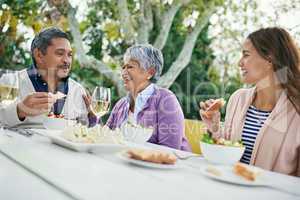 Dads jokes have them rolling in the aisles. Cropped shot of a family enjoying lunch and wine together outside.