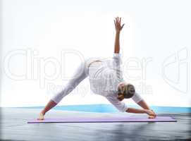 Demonstrating a perfect triangle pose. Shot of a gorgeous young woman doing yoga outdoors beside a pool.