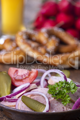 bayerischer Wurstsalat auf dunklem Holz