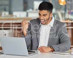 Allow inspiration to take hold and bring home the gold. Shot of a young businessman cheering while using a laptop in a modern office.