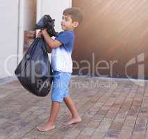 Time to take out the trash. Shot of a little boy taking out the trash at home.