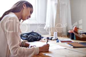 Coming up with new style trends. A fashion designer drawing sketches in her office.