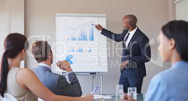 Forecasting their earnings. Shot of a business manager presenting financial data to his colleagues during a meeting.