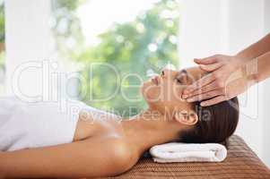 Healing hands. A young woman receiving a face massage.