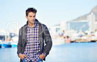 Spending a day at the waterfront. Shot of a handsome young man spending a day outdoors.