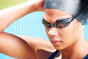 Finding her focus and feeling determined. Determined young female swimmer looking away - closeup.