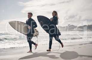 Were addicted to the rush. Shot of a young couple out surfing together at the beach.