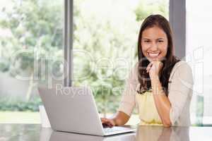 Getting great feedback on her blog. A young woman working on her laptop at home.