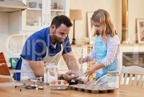 You can do it. Shot of a young man helping his daughter stir a bowl of cake mix.