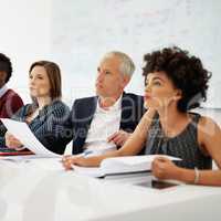 Interested in the information on offer. Cropped shot of a group of business colleagues sitting in on a presentation.