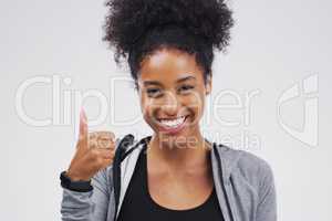 Approval is guaranteed. Studio portrait of an attractive young woman giving a thumbs up against a grey background.