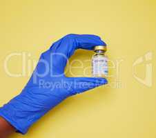 Each vaccine is handled with care. Shot of an unrecognizable person holding vaccine tubes against a yellow background.