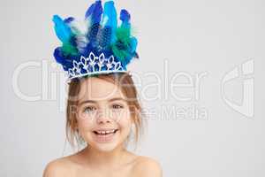 Princess for a day. Studio portrait of a cute little girl wearing a sparkly crown with feathers.