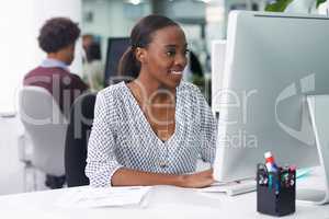 She thoroughly enjoys her job. Shot of a businesswoman working in an office.