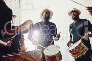 Their beats are on a whole new level. Shot of a group of musical performers playing drums together.