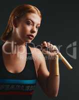 I skip right over challenges like its nothing. Studio portrait of a sporty young woman posing with a skipping rope against a black background.