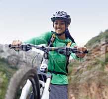 Exploring the face of the mountain. An attractive young woman mountain biking in a scenic setting.