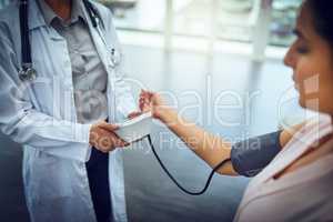 Blood pressure checks are all part of a routine checkup. Closeup shot of a doctor checking a patients blood pressure.