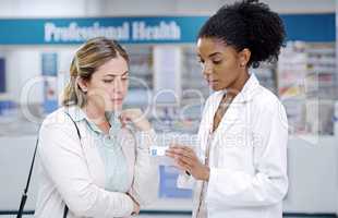 We always explain in detail to help you choose smarter. Shot of a young pharmacist recommending a health care product to a young woman at a pharmacy.
