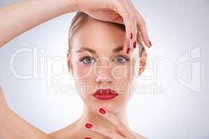 Highlighting her most beautiful features. Portrait of an attractive young woman wearing bright red lipstick and nail polish.