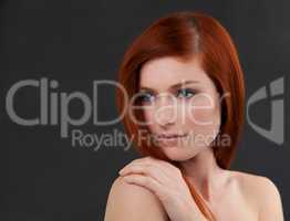 Her beauty is perfection. Studio shot of a gorgeous young redheaded woman against a black background.
