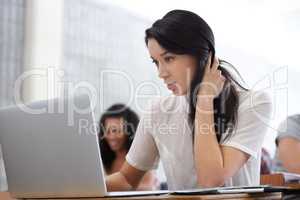 Bad grades getting you down. Shot of a bored young college student sitting at a laptop in class.