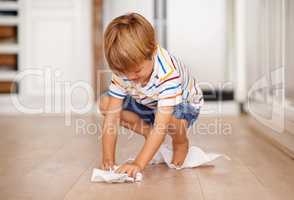 Cleaning up after himself. Shot of a little boy playing on the floor.