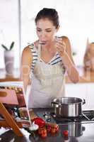The healthy life tastes good. Young woman cooking at home.