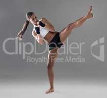 Kicking it up a notch. Full length shot of an athletic young woman practicing her kickboxing technique.