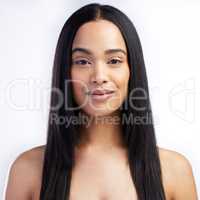 Straight hair is easier to manage. Shot of an attractive young woman standing alone in the studio.