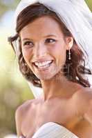 Shes a blushing bride. Gorgeous young bride looking away in her wedding dress and veil.