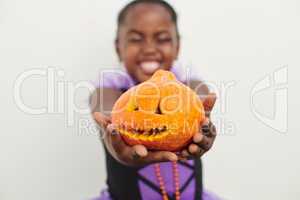 Cutest pumpkin in the patch. Shot of a little girl holding a jack o lantern against a white background.