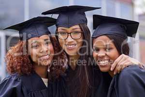 We did it together. Cropped shot of three young woman on their graduation day.