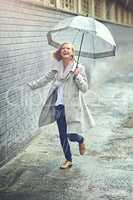 The rain never bothered her anyway. Full length shot of an attractive young woman playing in the rain.