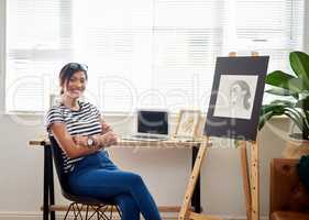Let the world stare in amazement of your creativity. Portrait of an attractive young artist smiling and feeling cheerful while sitting inside her studio at home.