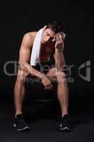 Rest is part of the program. Studio shot of a muscular bare-chested young man isolated on black.